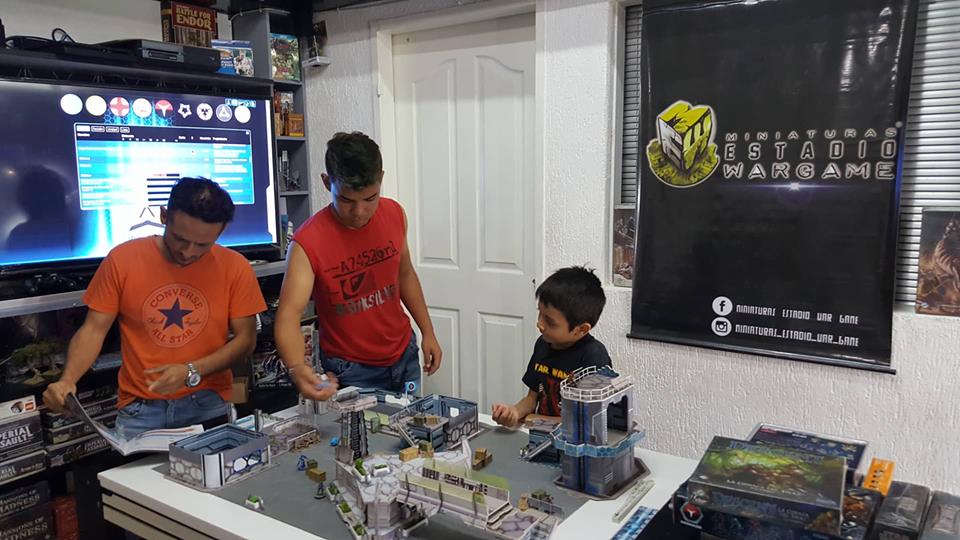 La familia de Miniaturas Estadio Wargame jugando Infinity